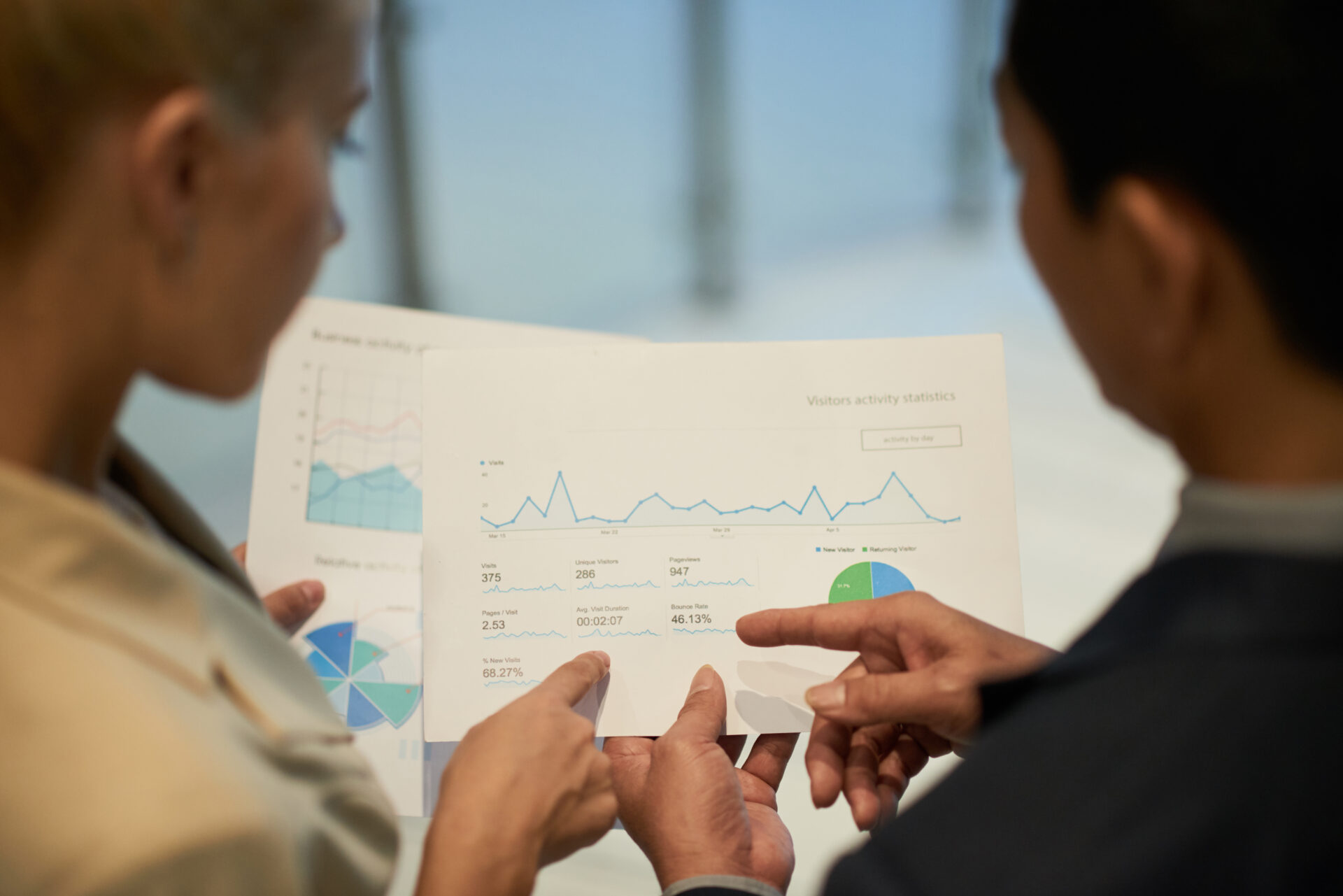 Financial managers analyzing data in report with charts and diagrams